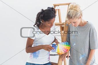 Cheerful housemates choosing colour for wall