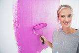 Pretty blonde painting her wall pink