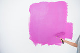Woman painting her wall in pink