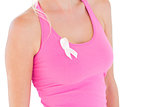 Woman wearing pink top and ribbon for breast cancer