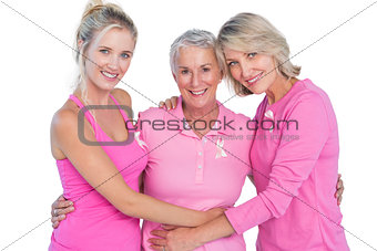 Happy women wearing pink tops and ribbons for breast cancer