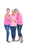 Smiling women wearing pink tops and ribbons for breast cancer