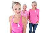 Three generations of women wearing pink tops and breast cancer ribbons