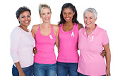 Smiling women wearing pink tops and breast cancer ribbons