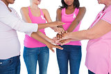 Women wearing breast cancer ribbons with hands together
