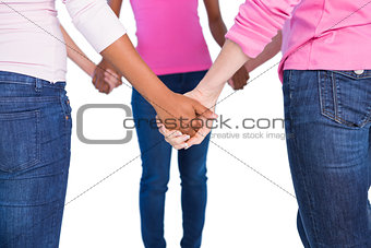 Women wearing pink for breast cancer holding hands