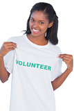 Young woman wearing volunteer tshirt and pointing to it