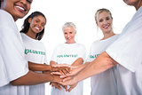 Group of female volunteers with hands together smiling at camera