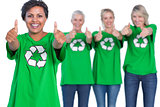 Happy women wearing green recycling tshirts giving thumbs up
