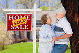 Sold Real Estate Sign with Senior Couple in Front of House