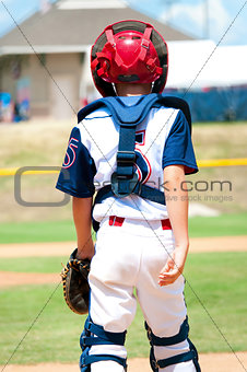Young baseball catcher during game.