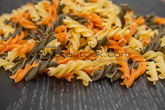 Colorful Pasta spreading on black wood table background