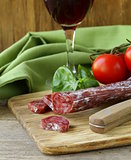 Still life of delicacy salami, tomatoes and basil -  rustic style