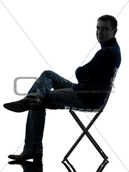 man sitting smiling looking at camera silhouette full length