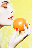 Woman portrait smelling an orange tangerine fruit