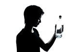 one young teenager boy or girl holding empty vodka alcohol bottl