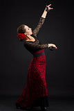 Spanish woman dancing flamenco on black