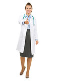 Full length portrait of smiling doctor woman stretching hand for