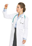 Surprised doctor woman looking on thermometer