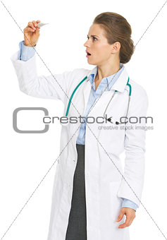 Surprised doctor woman looking on thermometer