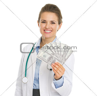 Smiling doctor woman showing fan of dollars