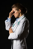 Portrait of frustrated doctor woman isolated on black