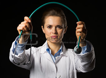 Doctor woman giving stethoscope isolated on black