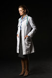 Full length portrait of thoughtful doctor woman isolated on blac