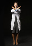 Full length portrait of serious doctor woman showing stop gestur