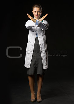 Full length portrait of serious doctor woman showing stop gestur