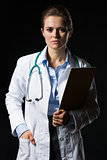 Portrait of doctor woman with clipboard isolated on black