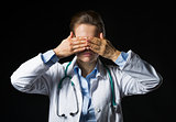 Portrait of doctor woman showing see no evil gesture isolated on