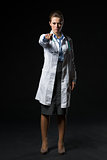 Full length portrait of serious doctor woman pointing in camera 