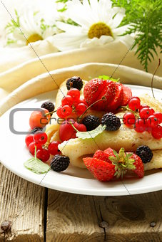 thin dessert pancakes (crepes) with various berries