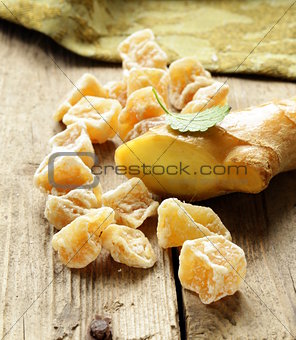 sugared ginger (candied) and fresh root on a wooden table