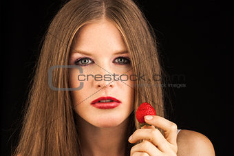 Young lady eating a strawberry