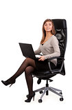 Young business lady in a chair with a laptop 