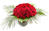 A large bouquet of red roses in a transparent glass vase. The is