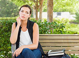 Melancholy Young Adult Woman Sitting on Bench Next to Books 