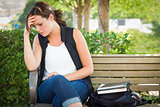 Upset Young Woman Sitting Alone on Bench Next to Books