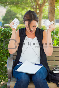 Upset Young Woman with Pencil and Crumpled Paper in Hands