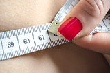 Detail of a woman measuring her waist