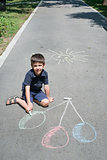 Child drawing balloons on asphalt