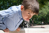 Child drinking water from a fountain