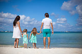 Young beautiful family with two kids walking at tropical beach