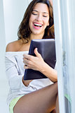 Beautiful woman at home using a digital tablet