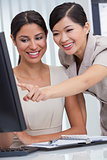 Asian Chinese & Hispanic Businesswomen Using Office Computer