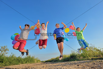 happy children jumping on field with balloons