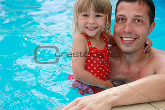 Dad and little daughter in the water pool