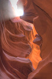 Ray of sunlight entering Antelope Canyon smooth red rock formati